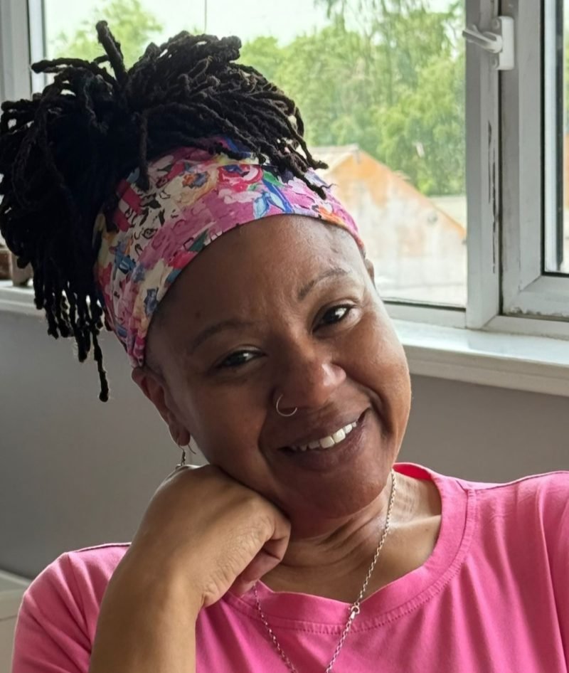 Portrait of Tracey, therapist at Annais Therapy, smiling in a pink top and floral headband